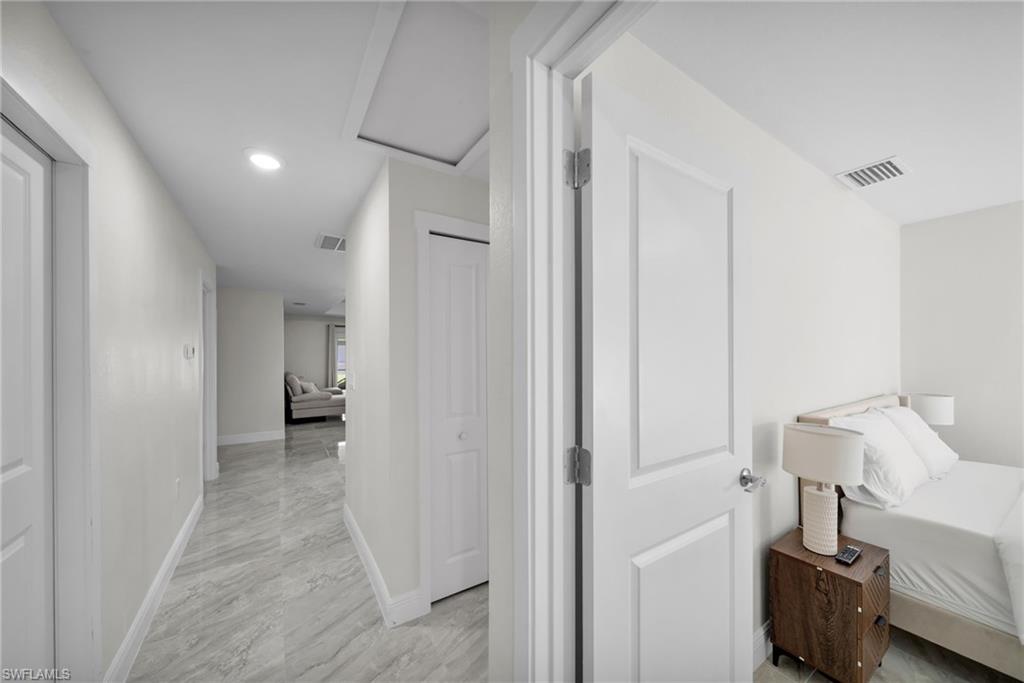 Hallway with light-toned plank flooring and recessed lighting
