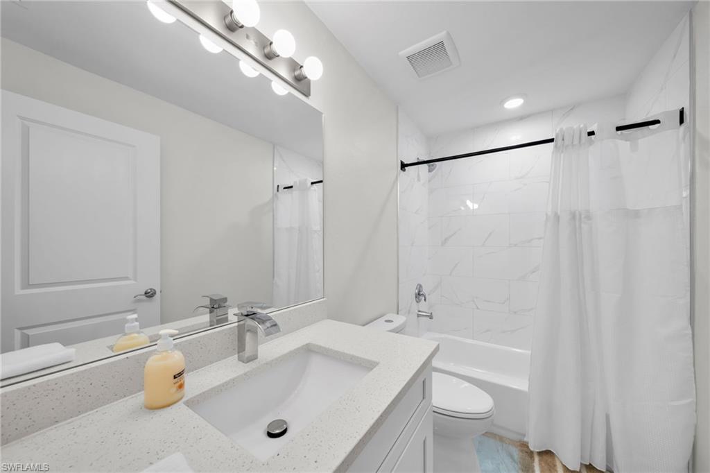 Contemporary bathroom featuring a white vanity with a light-colored countertop, an undermount sink, and a chrome faucet