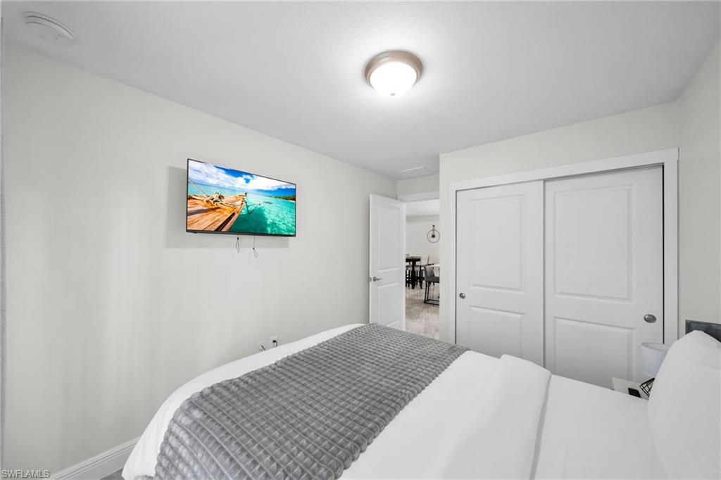 Bedroom featuring a ceiling-mounted light fixture, sliding closet doors, and light-colored walls