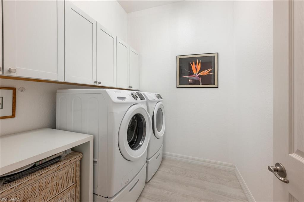 Great size laundry room with cabinet storage and pedestals for the front load washer and dryer.