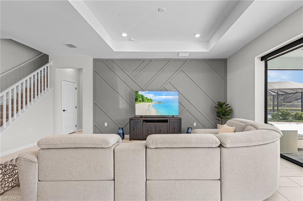 Living space featuring a coffered ceiling, recessed lighting, and a decorative accent wall