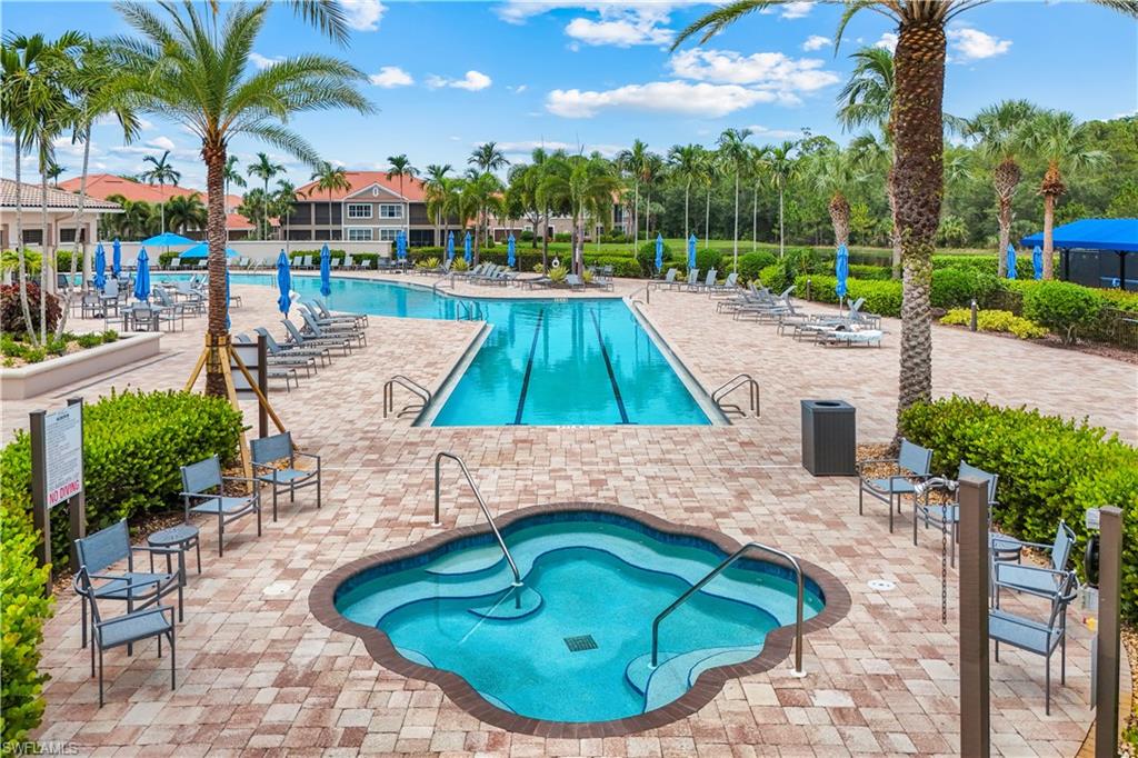 Multi-level swimming pool area featuring a spa, a lap pool, and a recreational pool, all surrounded by paver decking and extensive tropical landscaping