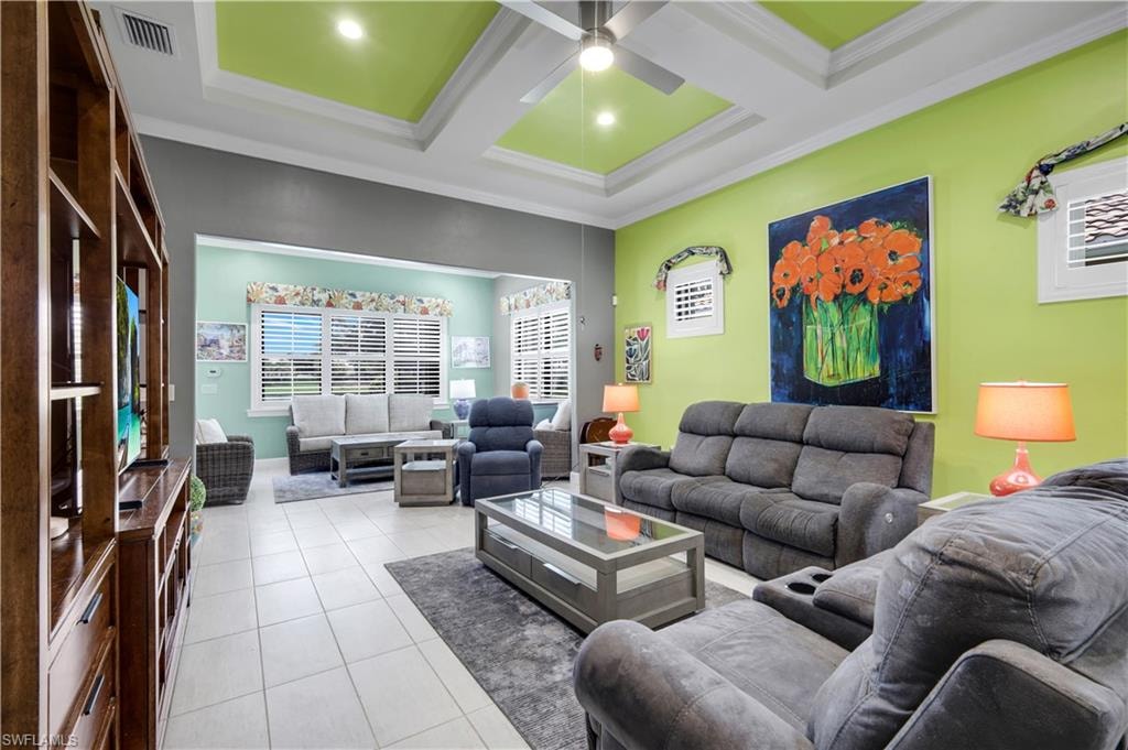 Spacious room featuring a tray ceiling with recessed lighting and a ceiling fan