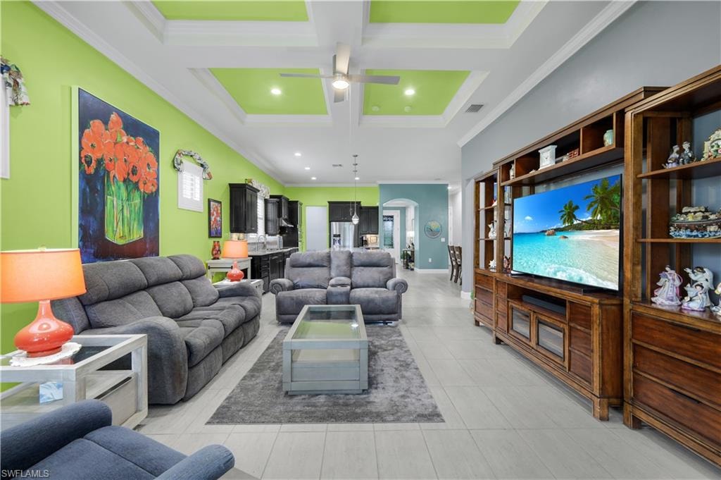 Open-concept living space featuring a tray ceiling with recessed lighting, large format plank-tile flooring.