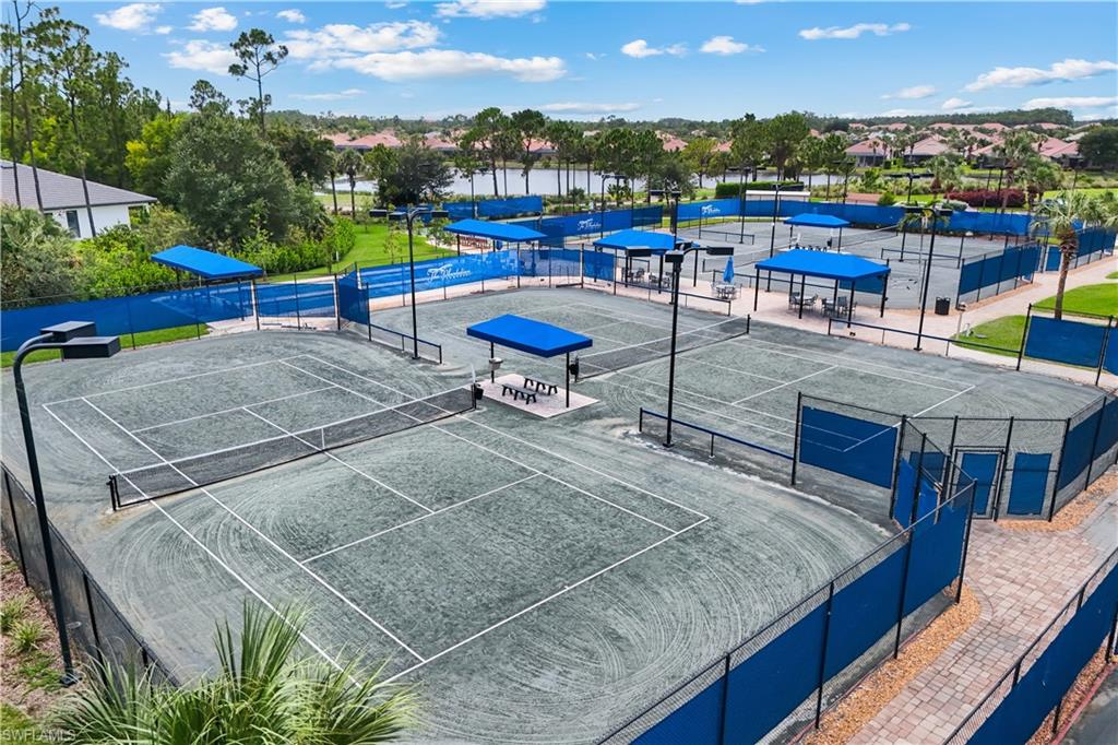 PICKLEBALL courts, shaded seating areas, overhead lighting.