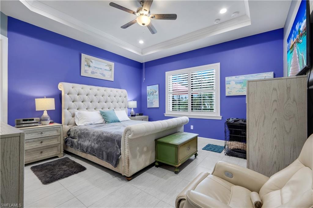 Spacious Primary Bedroom featuring vibrant walls, a tray ceiling with recessed lighting and a ceiling fan, with plantation shutters