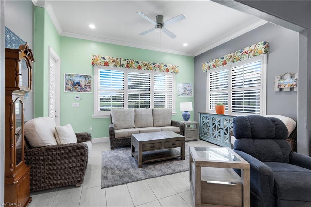 Spacious Sunroom area featuring light-toned plank-tile flooring, planation shutters, crown molding, and recessed lighting.  *** Door leads out to the Screened-in Lanai and pool area.