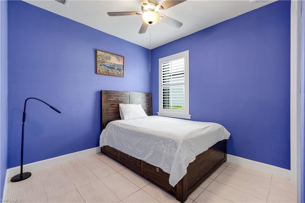 Interior bedroom with light-toned plank-tile flooring, plantation shutters and vibrant walls