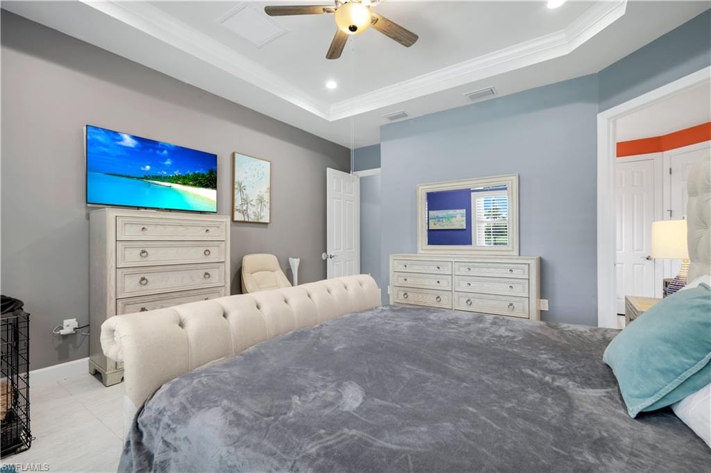 Primary Bedroom with tray ceiling with crown molding and recessed lighting
