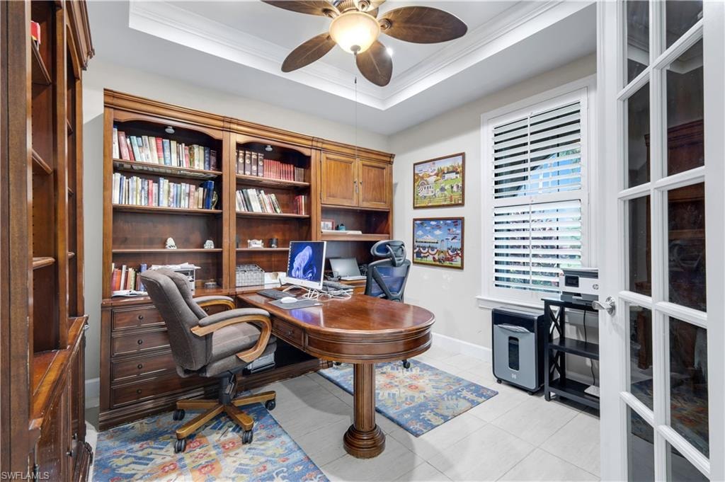 Office/Den space featuring, a decorative ceiling fan, tray ceiling, and plantation shutters