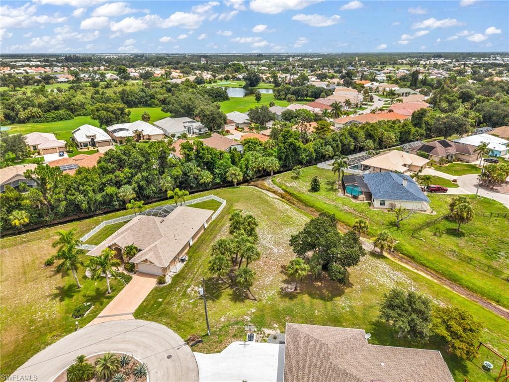 Aerial view showcasing a residential area with a prominent golf course and multiple water features