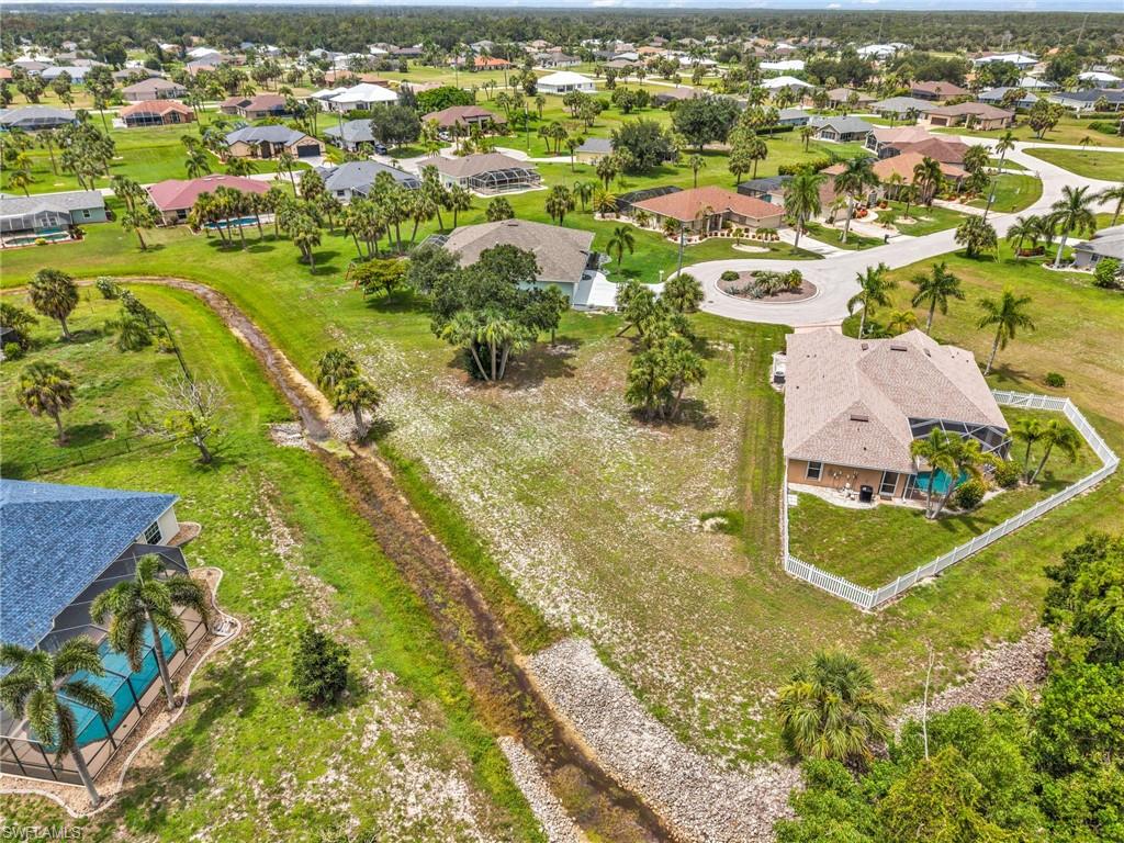 Expansive residential property featuring a screened-in swimming pool and a white privacy fence