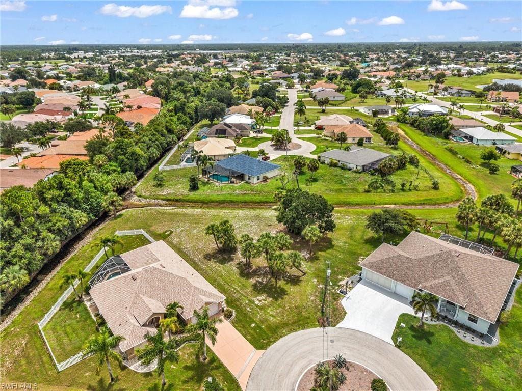 Aerial perspective of a residential neighborhood featuring single-story homes with shingled roofs and private swimming pools