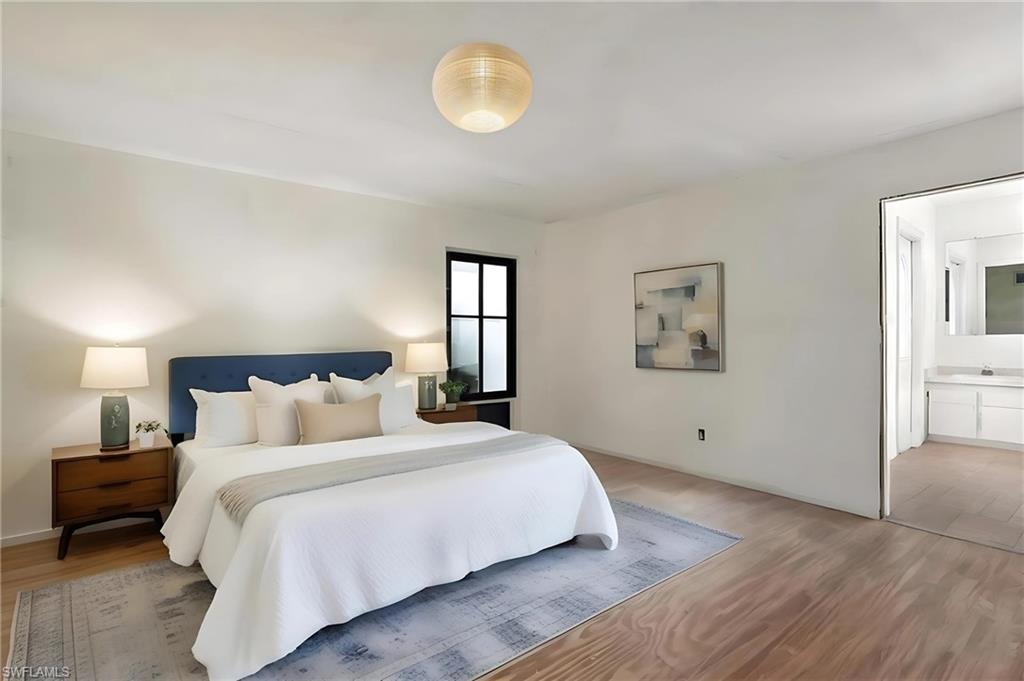 Bedroom 1 featuring light wood-style floors and ensuite bathroom - Virtually Staged and Edited Image. first floor