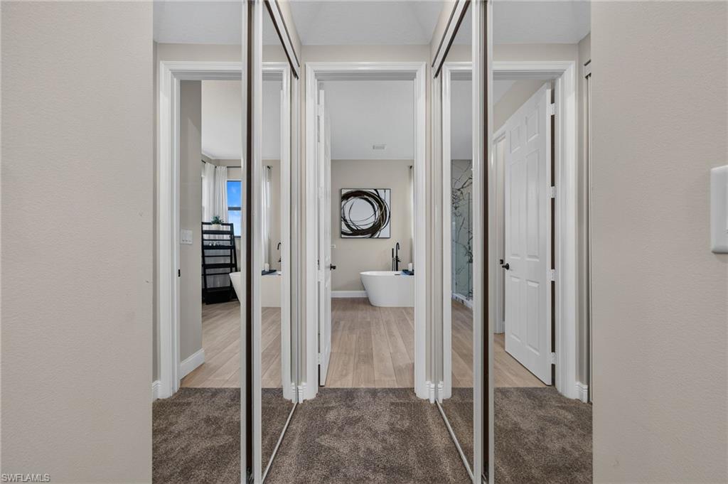 Hallway featuring mirrored sliding closet doors