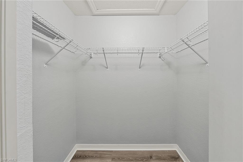 Alcove featuring white wire shelving, wood-finish flooring, and white baseboards