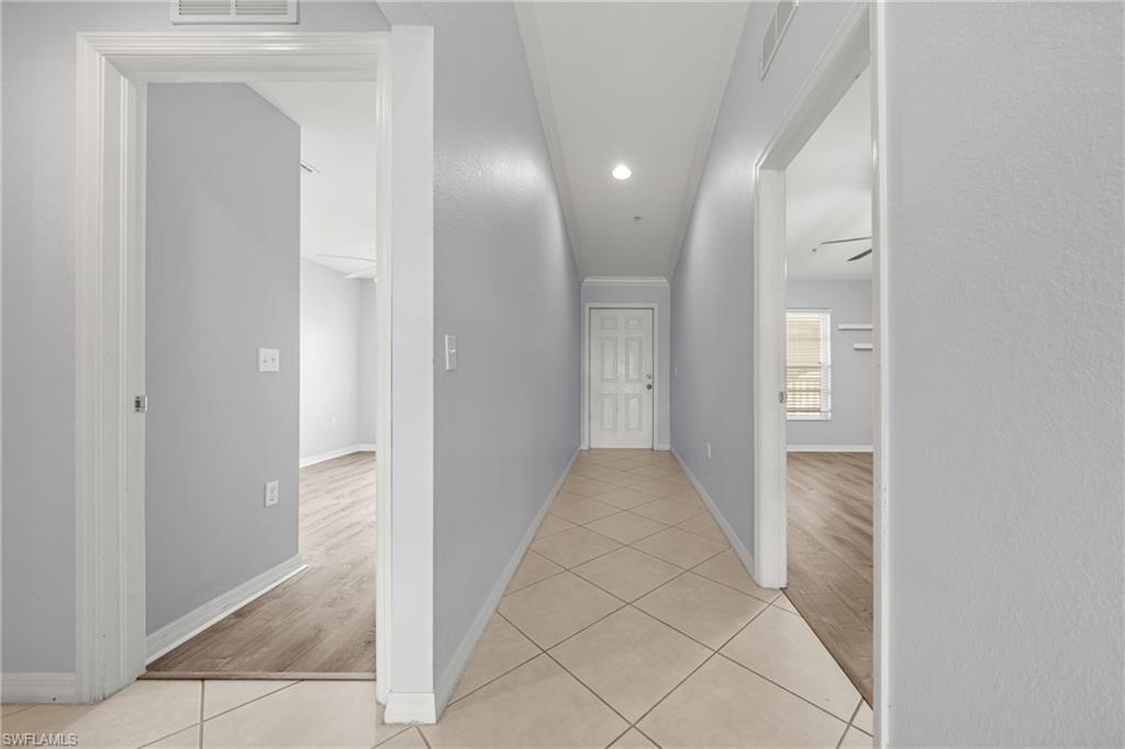 Neutral-toned hallway featuring diagonal tile flooring and recessed lighting