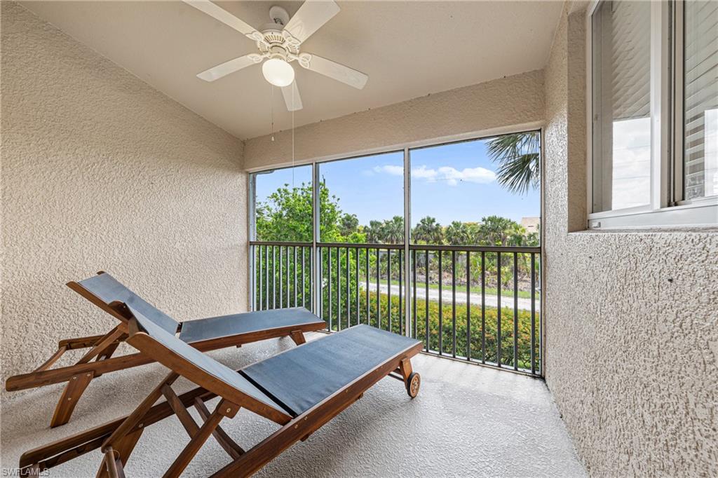 Screened balcony with textured walls and a ceiling fan