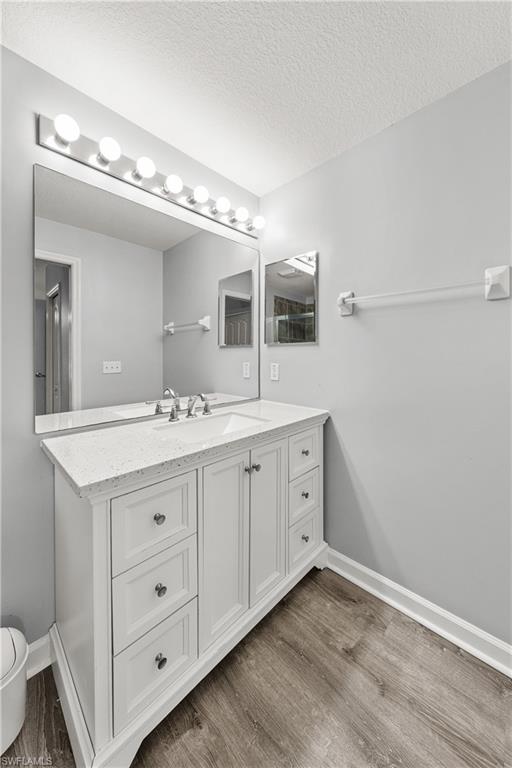 Bathroom vanity featuring a white cabinet with extensive drawer storage, an integrated sink, and a speckled countertop