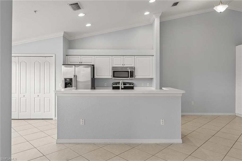 Kitchen featuring white cabinetry, stainless steel appliances, and a breakfast bar