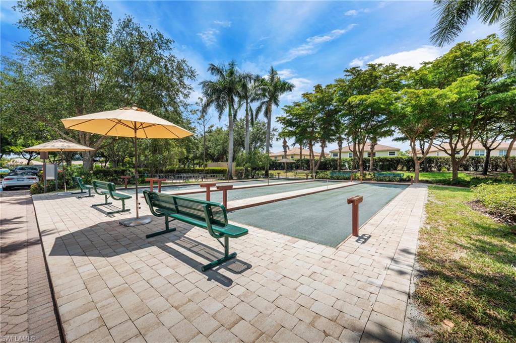 Bocce ball court featuring two lanes, surrounded by paver stone decking and mature landscaping