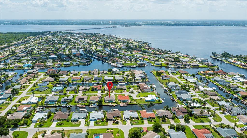 Waterfront residential community featuring a network of canals, direct access to a broad body of water, lush green landscaping, and numerous properties with private docks