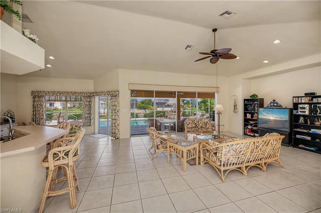 Spacious living area featuring large format tile flooring and vaulted ceilings