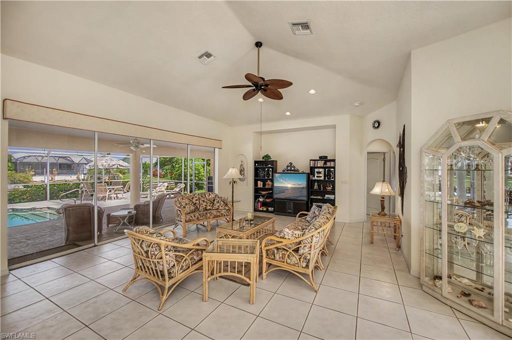 Spacious living area featuring large format tile flooring and vaulted ceilings
