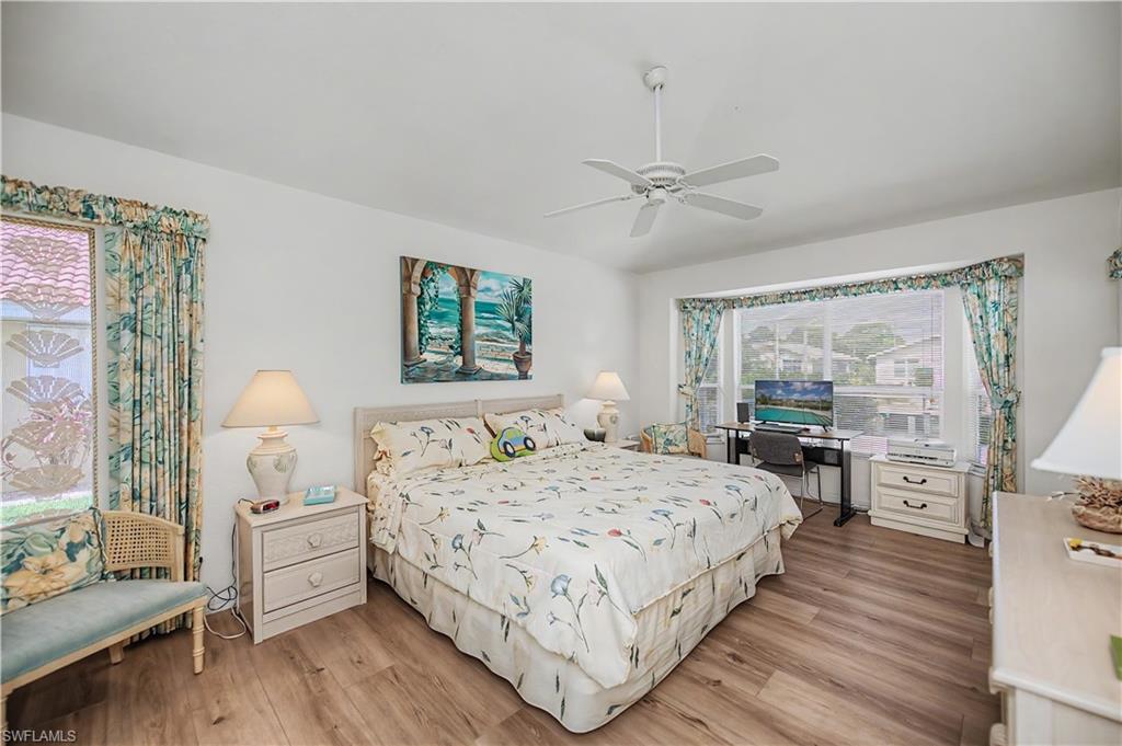 Bright bedroom featuring wood-finish flooring and a white ceiling fan