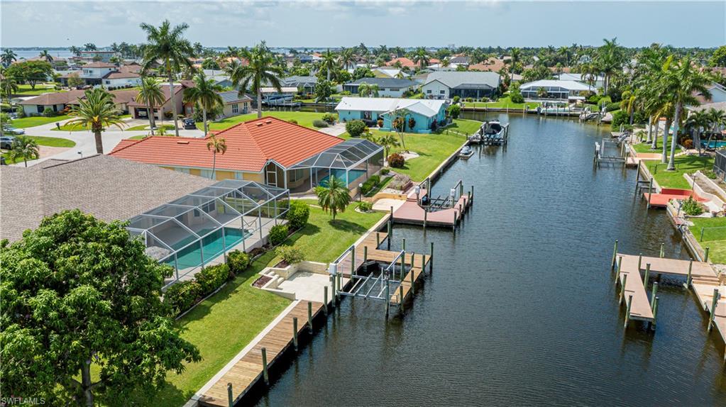 Waterfront property featuring a private boat dock, boat lift, and screened swimming pool