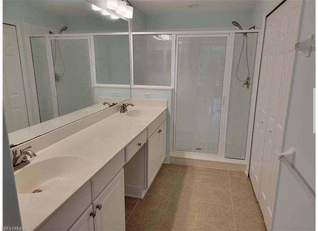 Bathroom featuring tile patterned flooring, an enclosed shower, and vanity