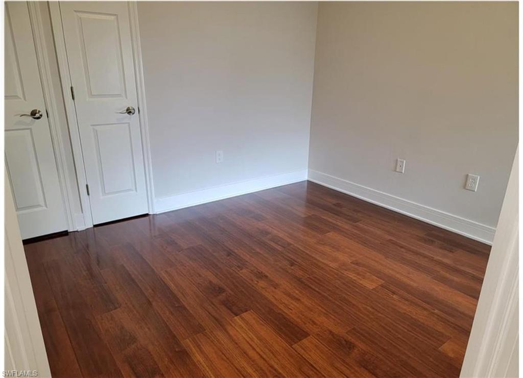 Unfurnished room with dark hardwood / wood-style floors