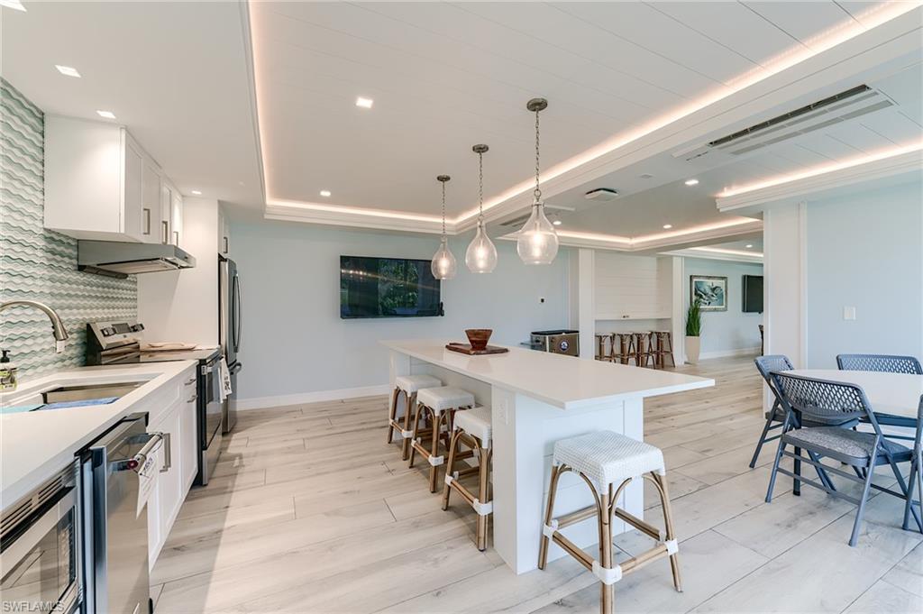 White cabinetry, integrated stainless steel appliances, and a quartz countertop