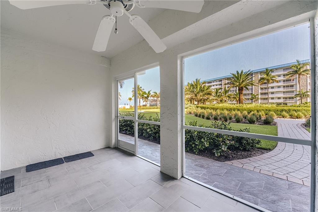 Screened patio with a ceiling fan, sliding glass door, and tile flooring