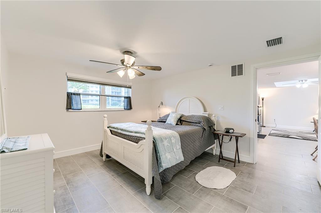 Recessed window with blinds, ceiling fan with integrated lighting, and tile flooring