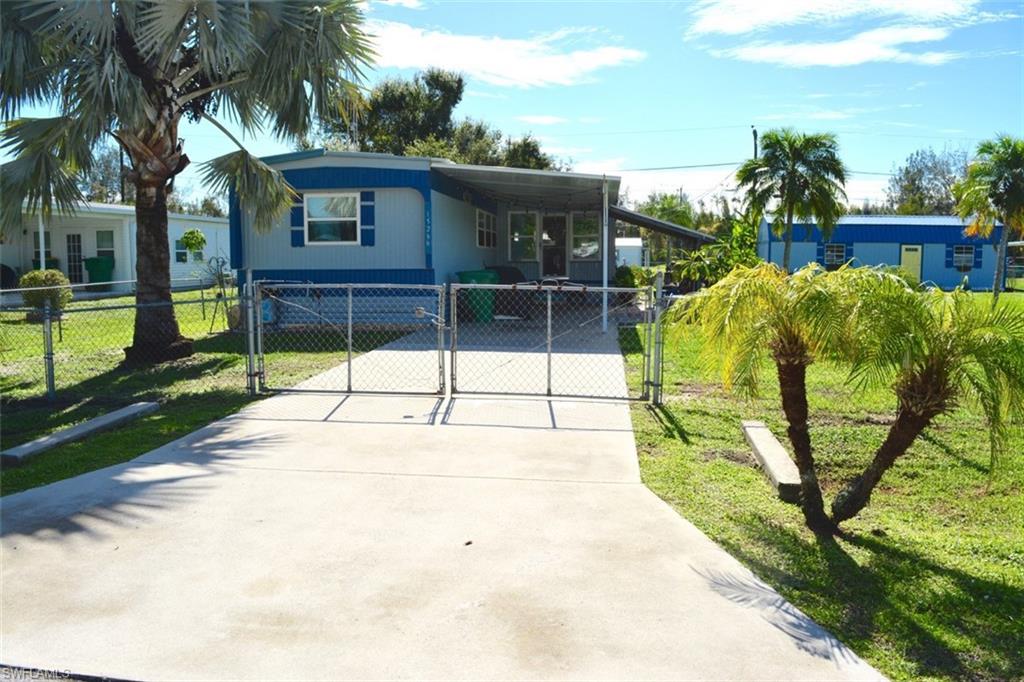 Concrete driveway with double gate entry, leading to a single-story residence with a covered porch