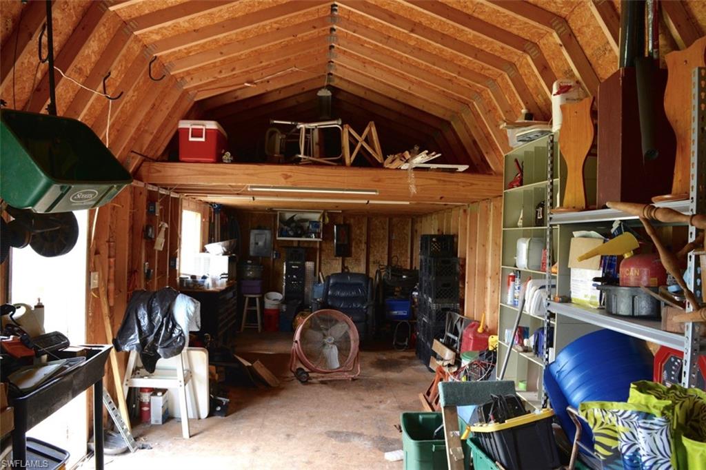Spacious utility building with exposed wood framing, a high gambrel roof, and a visible loft area
