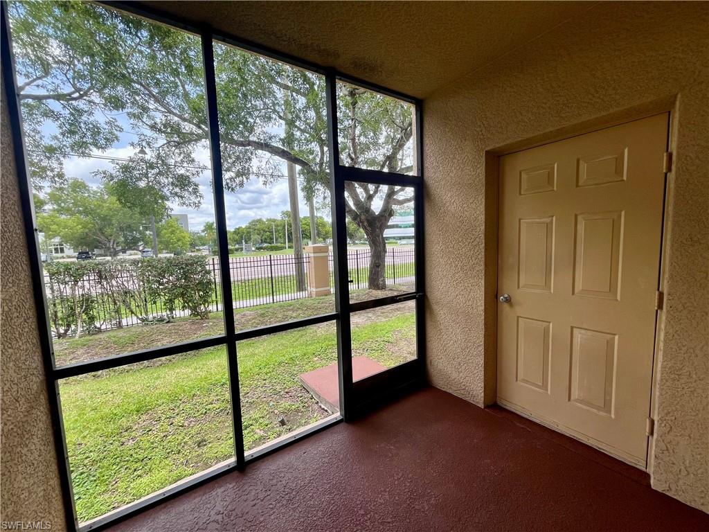 Screened-in patio with textured walls and a textured red-brown floor