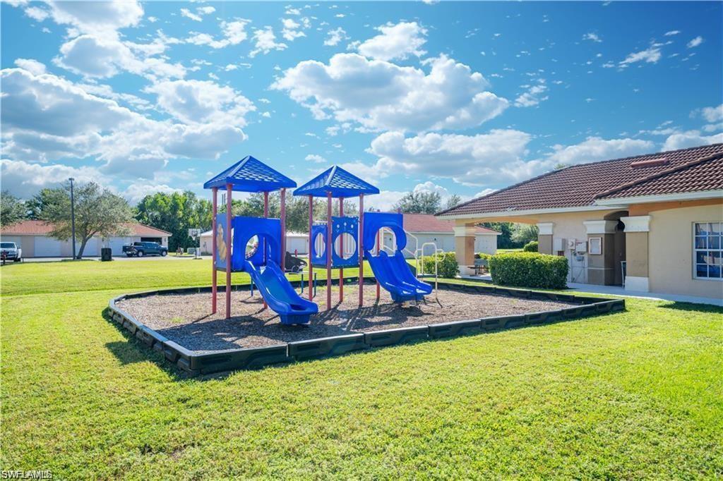 Community playground featuring multiple slides and climbing structures over a wood chip surface