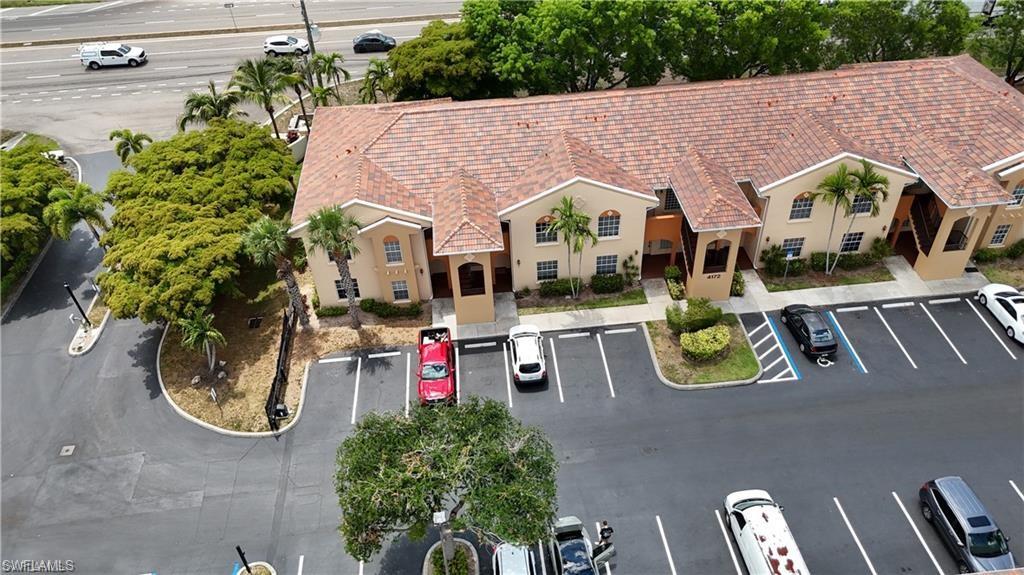 Multi-story residential building featuring a barrel tile roof and stucco exterior