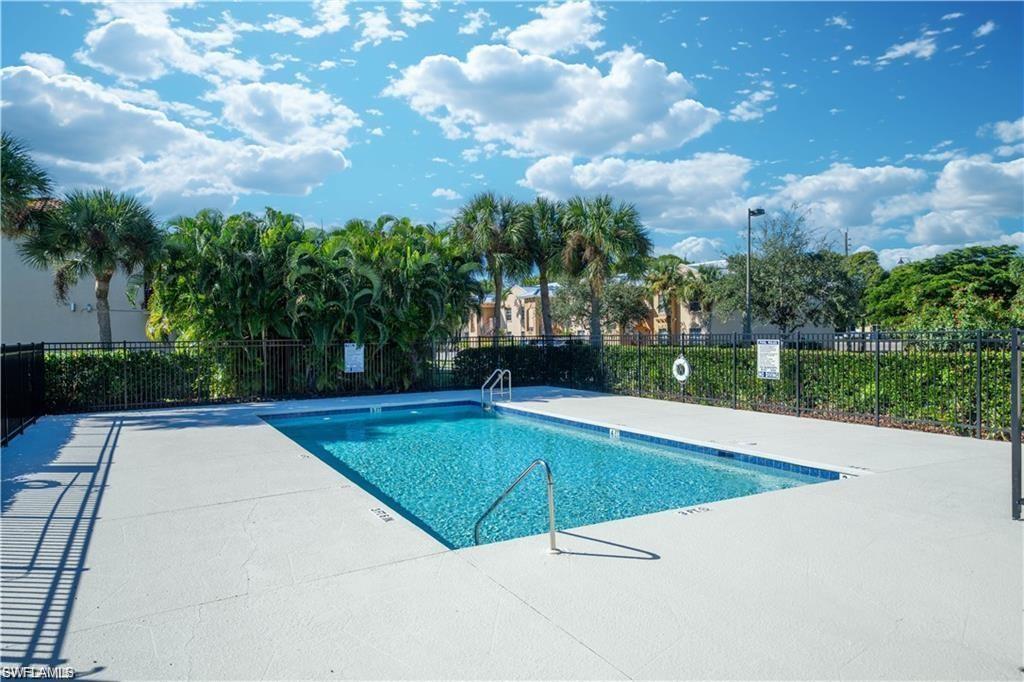 Rectangular swimming pool featuring a light blue tiled interior and integrated metal handrails