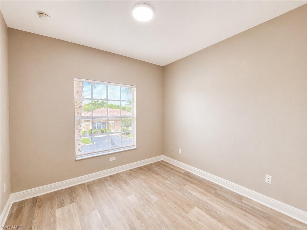 Interior room featuring light-toned walls and wood-finish flooring