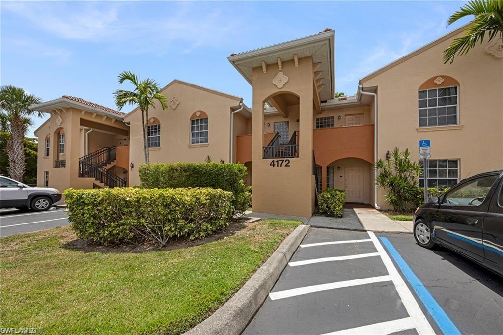 Mediterranean-style multi-story building featuring stucco exterior, arched windows, and a tiled roofline