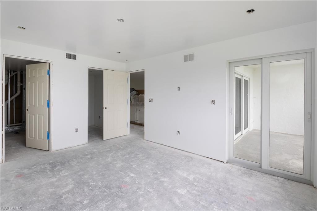 Primary Bedroom with ensuite bath and impact slider leading onto the lanai