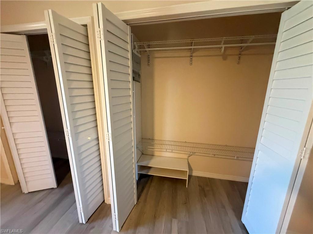 Closet featuring louvered bi-fold doors, wire shelving, and wood-finish flooring