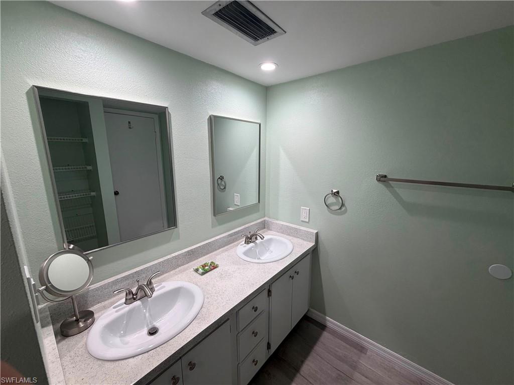 Double vanity featuring oval sinks, brushed nickel faucets, and a speckled countertop