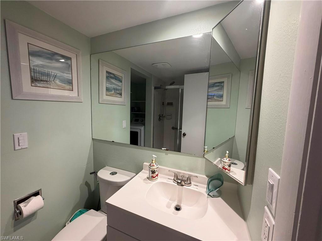 Bathroom vanity featuring a white countertop with an integrated sink, chrome-finish faucet, and a large wall-mounted mirror