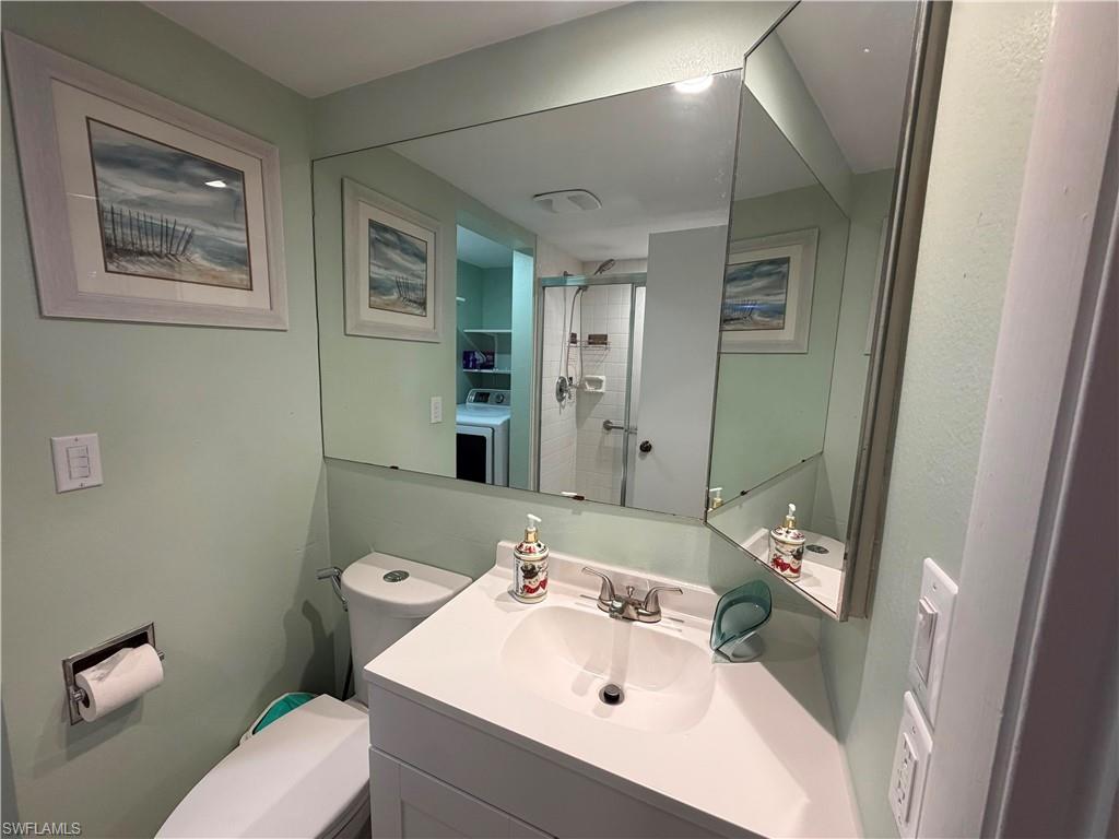 Vanity with a white sink and chrome faucet, set against light green walls