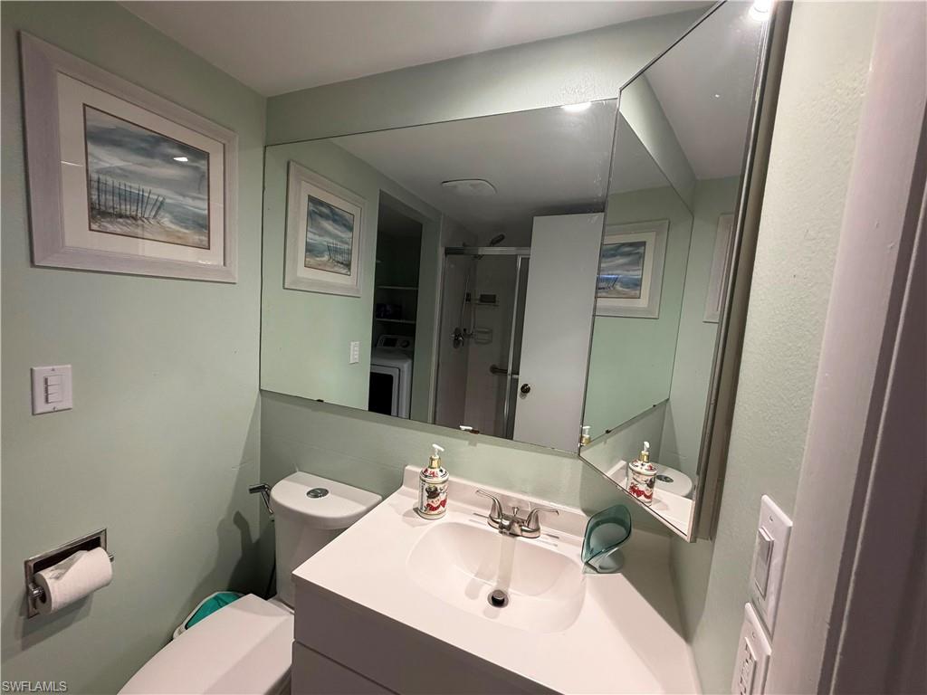 Bathroom vanity featuring an integrated sink, polished chrome faucet, and a large wall-mounted mirror