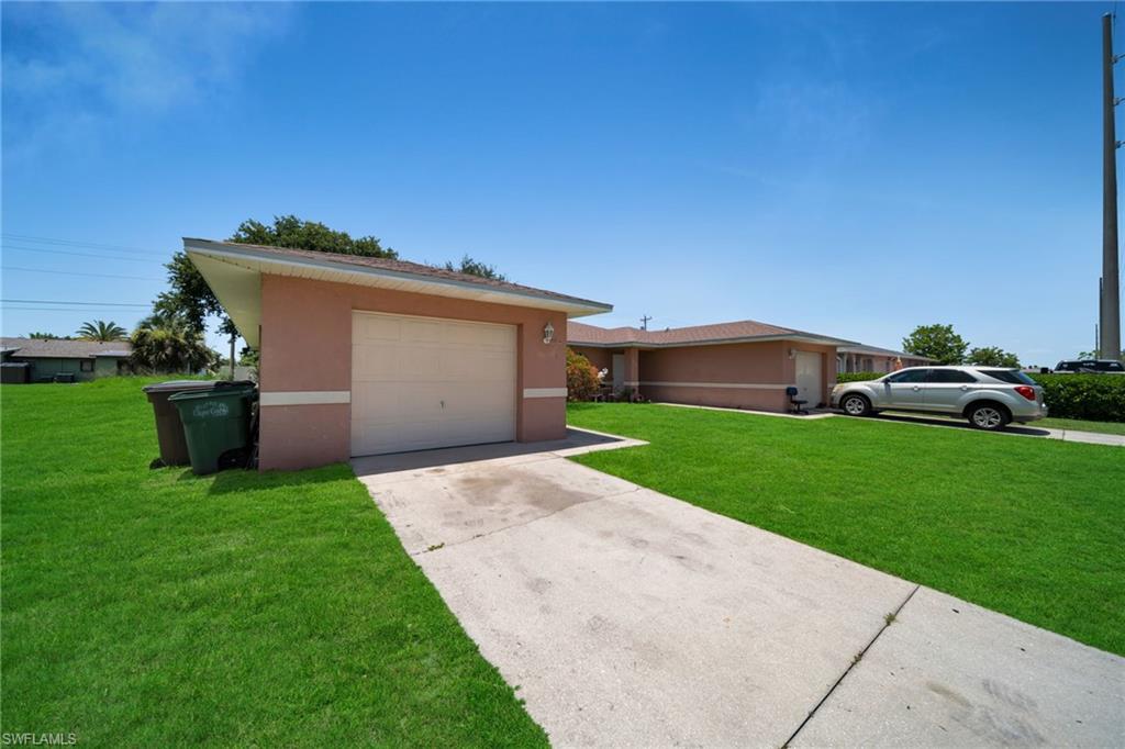 Single-story residence featuring a two-car garage with an overhead door, a concrete driveway, and a well-maintained lawn